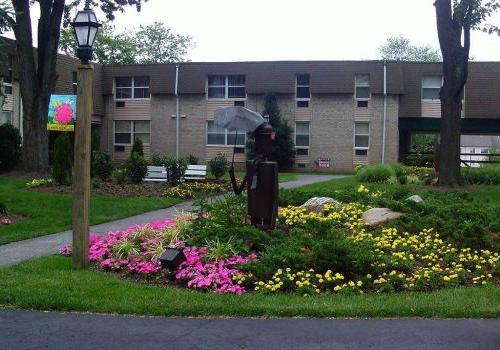 Garden with pink and yellow flowers outside of 450 Green apartments for rent in Norristown, PA